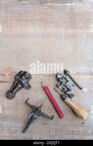 Eine alte Meißel und andererseits Werkzeuge flach auf eine raue Oberfläche Stück Holz mit Farbe Spuren und Kratzer Stockfoto