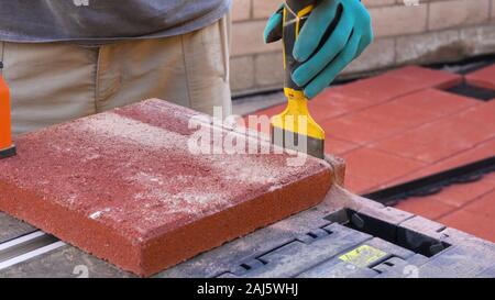 Tile cutter Industrie anlagen. Arbeiter schneiden Bodenplatten für die Verlegung auf der Terrasse mit Kreissäge elektrische Stockfoto