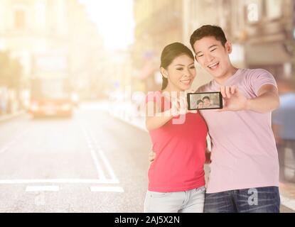 Asiatische Paare einen selfie mithilfe einer Kamera Handy in der Stadt Stockfoto