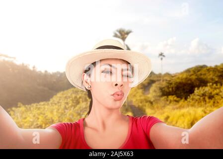 Asiatische Mädchen in hat einen selfie mit einem lustigen mit der Kamera Handy mit campuhan Ridge Gesicht Spaziergang Hintergrund Stockfoto