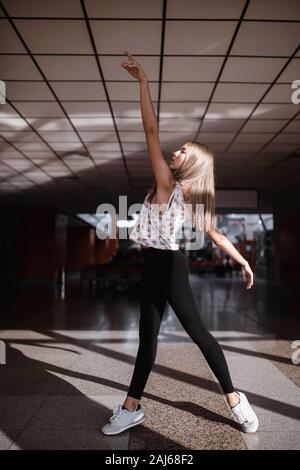 Junge Frau tanzt in einem Wartezimmer Stockfoto