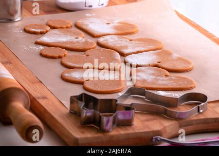 Vorbereitung für den Urlaub. Vorbereitung für das Neue Jahr. Lebkuchen Leerzeichen vor dem Backen. Gingerbread cookies mit Bohrungen zum Aufhängen an Weihnachten ein t Stockfoto