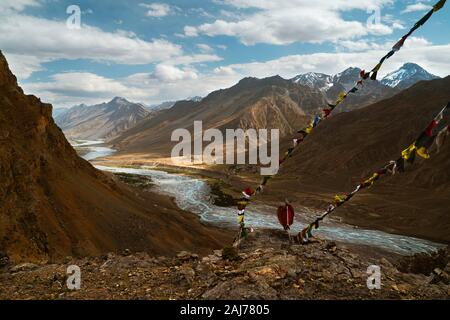 Die spiti Fluss schlängelt sich durch die Spiti Valley von der hohen Himalaya und Buddhistische Gebetsfahnen an einem schönen Sommertag in der Nähe von Kaza, Indien flankiert. Stockfoto