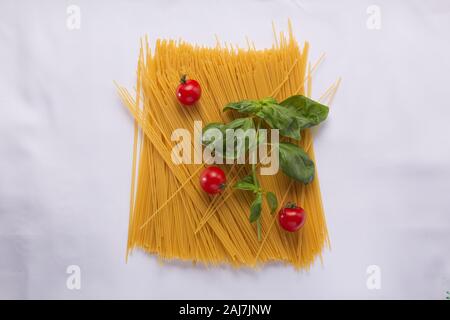 Frische Zutaten, Makkaroni, Teller ungekocht, Basilikumblätter, Ungekocht raw, Pasta, Spaghetti Bolognese, traditionelle italienische Stockfoto