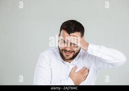 Close-up Portrait von glücklich aussehenden bärtigen Mann lachend auf grauem Hintergrund Stockfoto