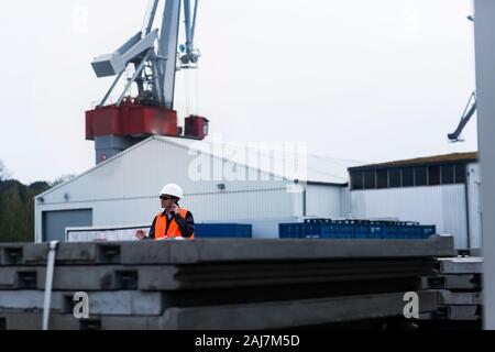 Arbeiter mit Helm in der Nähe eines Krans Stockfoto