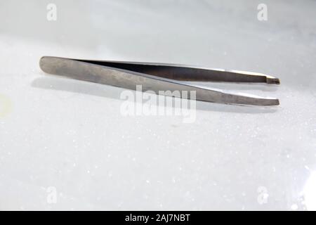 Anatomische Pinzette auf weißem Hintergrund. Stahl Pinzette auf weißem Hintergrund. Metall Pinzette auf weißem Hintergrund. graues Metall Stockfoto