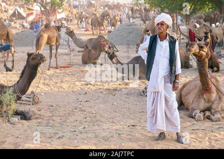 Pushkar, Indien - 19.November 2015. Ein Rajasthani kamel Trader, das Tragen der traditionellen Kleidung, steht in einem Desert Camp bei der jährlichen Pushkar Camel Fair. Stockfoto