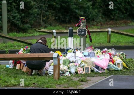 Eine Dame schaut floral Tribute, an der Szene in Stanwell geblieben sind, in der Nähe von London Heathrow Flughafen, der ein tödlicher Absturz am Silvesterabend in der drei British Airways Kabinenpersonal enthalten. Stockfoto