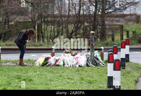 Eine Dame schaut floral Tribute, an der Szene in Stanwell geblieben sind, in der Nähe von London Heathrow Flughafen, der ein tödlicher Absturz am Silvesterabend in der drei British Airways Kabinenpersonal enthalten. Stockfoto