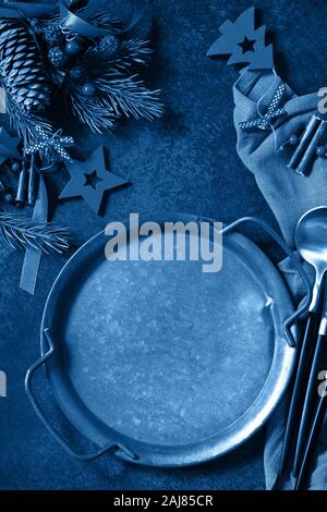 Classic blau 2020. Gradient Farbpalette. Christmas Dinner Konzept, kulinarischen Hintergrund. Metall Teller, Besteck und Serviette auf Stein Arbeitsplatten. Tabelle Stockfoto