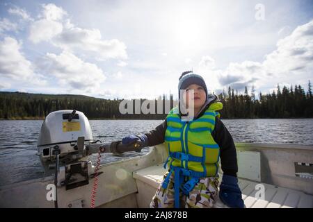 Kleinkind Junge fahren Motorboot auf See. Stockfoto