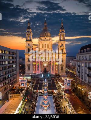 Budapest, Ungarn - Luftbild Drohne Blick auf Europas schönsten Weihnachtsmarkt mit den beleuchteten die St.-Stephans-Basilika, Eisbahn, Weihnachtsbaum Stockfoto