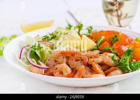 Obst Salat mit gebratenen Garnelen/Krabben, Kaki, roten Zwiebeln und Salat in weißen Schalen. Vorspeisen, Snack, Brunch. Gesundes Essen. Stockfoto