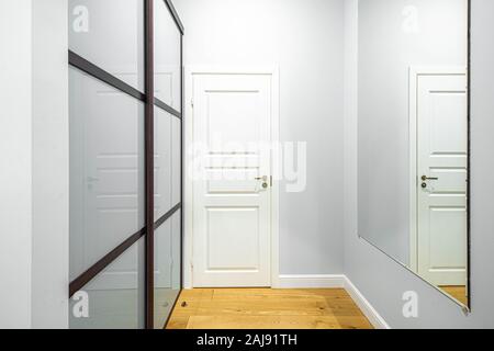 Geschlossen weiße Tür in der Halle. Spiegel und Glas Schiebetüren Kleiderschrank. Stockfoto