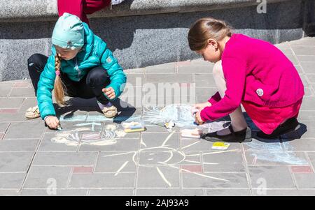 Samara, Russland - 25. Mai 2019: Junge Mädchen zieht auf einem Gehsteig mit Kreide in Farbe. Außerhalb Aktivitäten für Kinder im Sommer Stockfoto