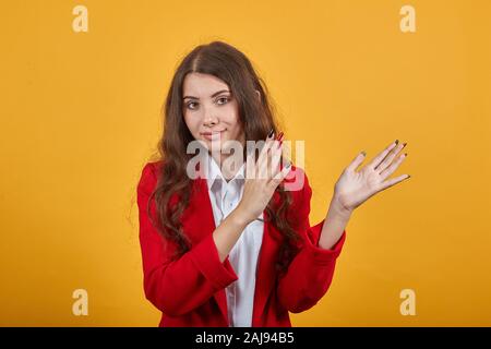 Attraktive Frau in weißem Hemd und Jacke claps, an der Kamera suchen, lächelnd. Stockfoto