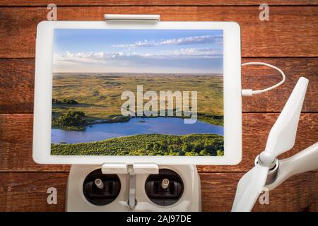 Flach und weit Dismal Fluss fließt durch Nebraska Sandhills, die Überprüfung eine Antenne Bild auf einem digitalen Tablette auf Drone Radio Controller montiert Stockfoto