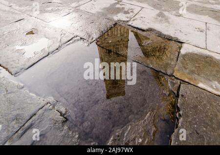 Blick auf den Glockenturm von Giotto in Florenz spiegelt sich in einer Pfütze Stockfoto