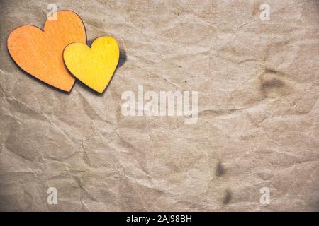 Zwei hölzerne Herz auf alten zerknittertes Papier. Valentines Tag Konzept. Flach, Ansicht von oben, kopieren. Stockfoto