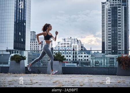 Junge athletische Frau in der modernen Stadt mit Wolkenkratzern auf dem Hintergrund Stockfoto