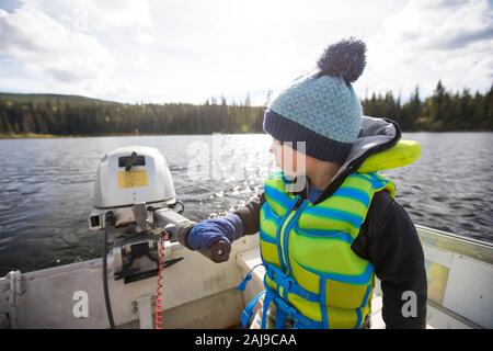 Kleinkind Junge fahren Motorboot auf See. Stockfoto