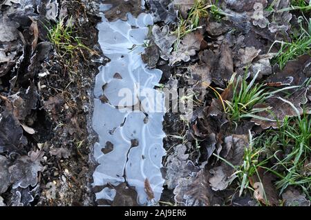 Nahaufnahme einer Reifenspur im Land unterwegs mit Eis auf kalten Wintertag Stockfoto