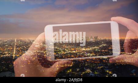 Doppelbelichtung Hände halten ein Handy und ein Bild von Stadt Los Angeles bei Nacht Stockfoto