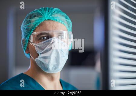 Männliche reife Chirurgen durch das Tragen von schützender Maske und Brille für den Betrieb am Krankenhaus bereit Stockfoto