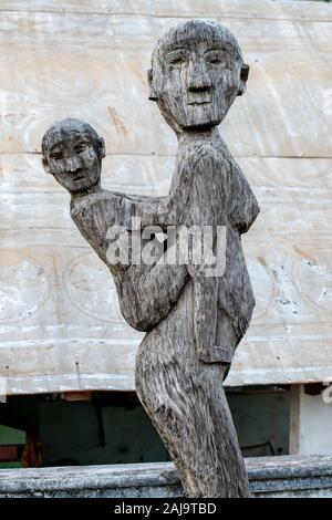 Eine alte Statue in scuplted Holz, die eine Mutter mit seinem Kind der Religion Animismus in Vietnam. Stockfoto