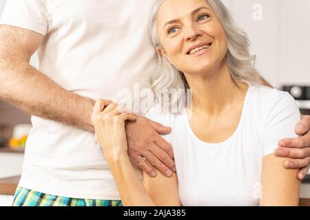 Attraktive glückliche Frau lehnt sich an einen Mann Stockfoto