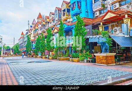 PATONG BEACH, Thailand - 30 april, 2019: Die bunten Häuser in einer ruhigen Straße von Kathu District mit der Linie der grünen Bäume und Pflanzen in Töpfen, am 30. April in P Stockfoto