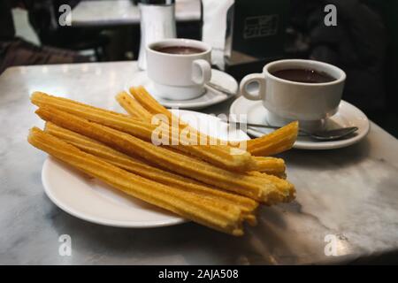 Churros und heiße Schokolade zu trinken San Gines in Madrid, Spanien. Stockfoto