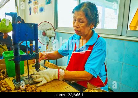 PHUKET, Thailand - 30 april, 2019: Der Prozess von Cashew-nüssen Hand in Shop von Cashew factory Peeling, am 30. April in Phuket Stockfoto