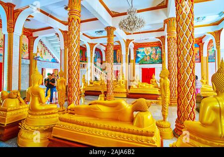 Hua Hin, Thailand - 30. APRIL 2019: Die malerische Innenraum des Wat Chalong Pagode mit zahlreichen vergoldeten Statuen des Buddha in verschiedenen Mudras (gestu Stockfoto