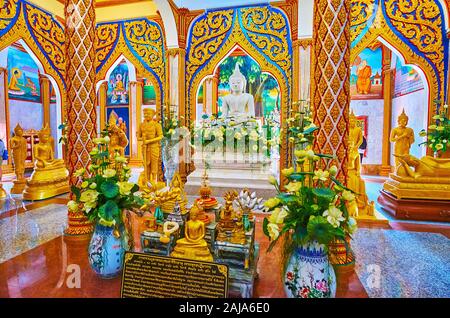 Hua Hin, Thailand - 30 april, 2019: Das prächtige Interieur Wat Chalong Pagode bild Halle mit Buddha Statuen, gewölbte Durchgänge und Spalten, mit r abgedeckt Stockfoto