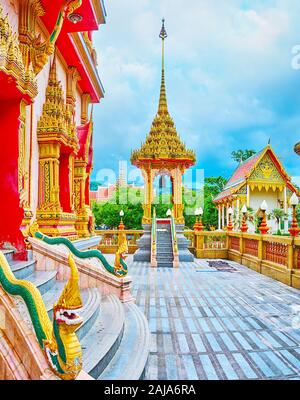 Der kleine Hof vor Wat Chalong Chedi mit grünen Naga Schlangen am Geländerpfosten und Treppen' tall Pavillon der mondop, gekrönt mit Turm und hti umb Stockfoto