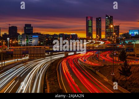 Blick von der Autobahn A1 auf die vier Türme (quattro Torres) in Madrid bei Sonnenuntergang mit Licht und Farben am Himmel Stockfoto