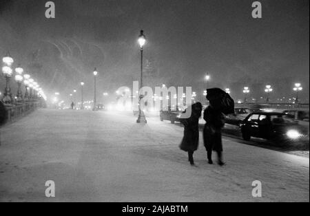 PARIS WINTER - Fußgänger kämpfen WIEDER EINE STARKE SCHNEESCHAUER - Paris Pont Alexandre III - LEICA NIGHT STREET FOTOGRAFIE - PARIS STREET FOTOGRAFIE - SILBER FILM © Frédéric BEAUMONT Stockfoto