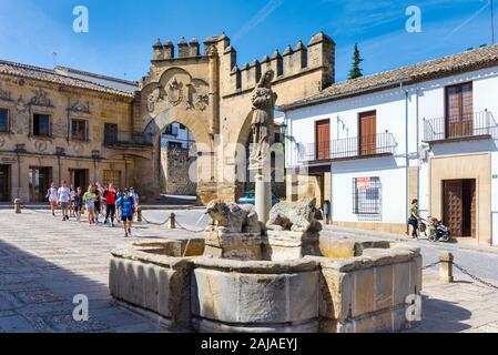Fuente de los Leones, oder Brunnen des Löwen, in der Plaza del Populo, Baeza, Provinz Jaen, Andalusien, Spanien. Die ornamentale City Gate in der Rückseite Stockfoto