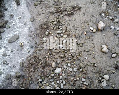 Einem ausgetrockneten Flussbett bei Ebbe mit Brackwasser Stockfoto