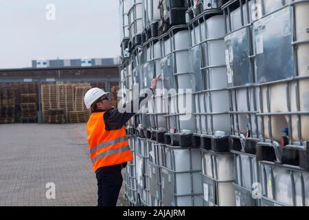 Arbeiter mit Helm in der Nähe von Tanks Stockfoto