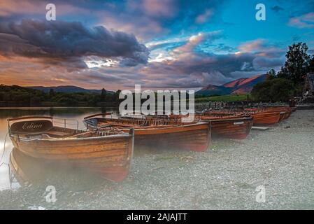 Ruderboote am Ufer des Derwent Water in der Nähe von Keswick bei Sonnenuntergang, Lake District, Cumbria, England, Uk, Gb Stockfoto