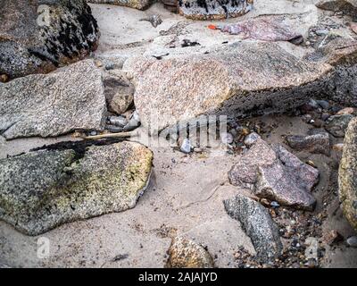 Felsen, Steinen und Sand bei Ebbe am Strand Stockfoto