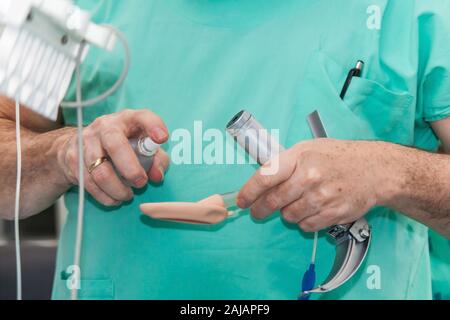 Anästhesisten eine endotracheale Intubation zu einem weiblichen Patienten zu Beginn einer Operation Stockfoto