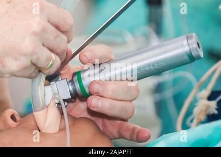 Anästhesisten eine endotracheale Intubation zu einem weiblichen Patienten zu Beginn einer Operation Stockfoto