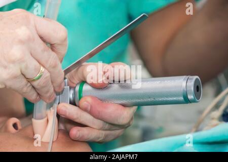 Anästhesisten eine endotracheale Intubation zu einem weiblichen Patienten zu Beginn einer Operation Stockfoto