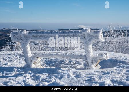 Verschneite Bank aus Holz Stockfoto