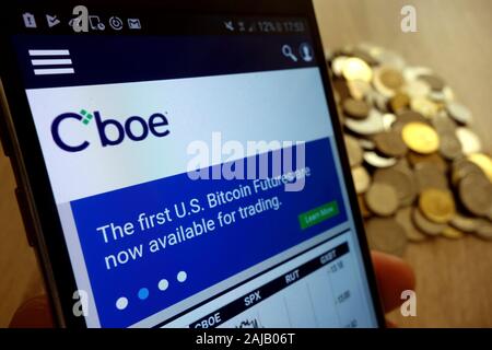 CBOE Global Markets Website angezeigt auf Smartphone und Stapel von Münzen Stockfoto