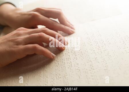 Blinder Mann liest den Text eines Braillebuches. Stockfoto